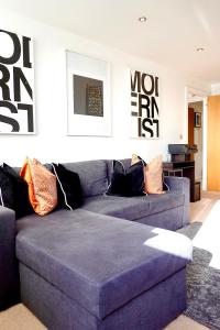 een woonkamer met een paarse bank met kussens bij Modern Luxurious Apartment in Birmingham