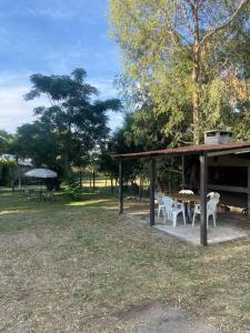 a pavilion with a table and chairs in a park at Sin Pensarlo 