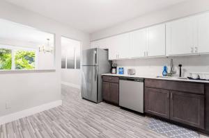 a kitchen with white cabinets and a stainless steel refrigerator at Rochester Hills 2BR/2BA Gem in Rochester Hills