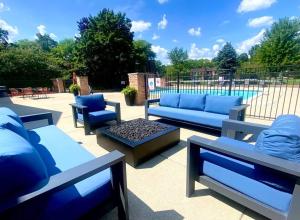 a patio with blue couches and a table and a pool at Rochester Hills 2BR/2BA Gem in Rochester Hills