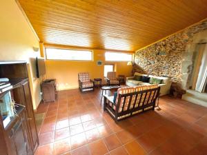 sala de estar con sofá, sillas y pared de piedra en Quinta Do Salgueiro B&B - Turismo Rural en Freixo de Espada à Cinta