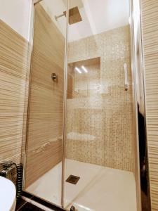 a shower with a glass door in a bathroom at Posada Verona Hedge in Verona