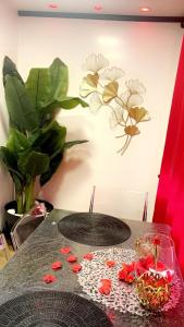 a table with a vase on top of it with flowers on it at C12 Deluxe in Cap d'Agde