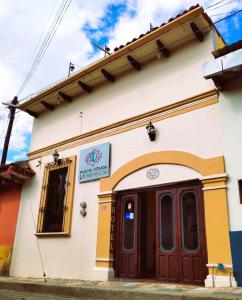 un edificio con una puerta roja en una calle en Hotel Posada Dominnycos, en San Cristóbal de Las Casas