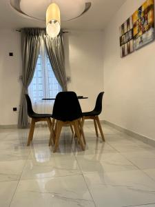 jadalnia ze stołem i krzesłami oraz oknem w obiekcie 7th Heaven Homes w mieście Ibadan