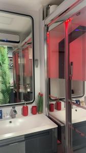 a bathroom with a sink and a large mirror at C12 Deluxe in Cap d'Agde