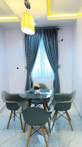 7th Heaven Homes في إيبادان: غرفة طعام مع طاولة وكراسي ونافذة