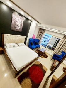 a bedroom with a white bed and blue chairs at البحر الاحمر الغردقة الهضبه in Hurghada