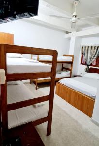 a room with three bunk beds and a tv at Hotel El Imperio in Santa Marta