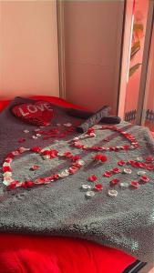 a bed with a blanket with red flowers on it at C12 Deluxe in Cap d'Agde
