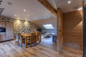 a dining room with wooden walls and a table and chairs at [Le LODGE] in Cauterets +16 photos