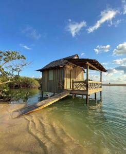 una pequeña cabaña en un muelle en el agua en Casa da Dilma Trancoso, en Trancoso
