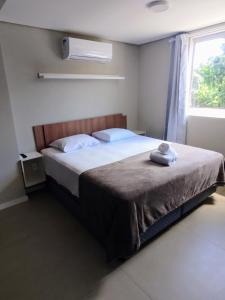 um quarto com uma cama e uma janela em Pousada Bombinhas House em Bombinhas