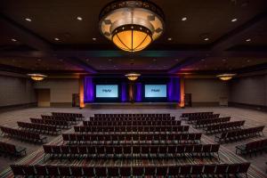 an auditorium with chairs and a stage with two screens at Sandia Resort and Casino in Albuquerque