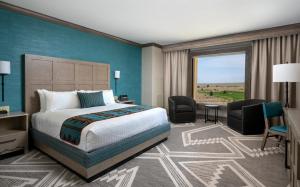 a hotel room with a bed and a desk and chairs at Sandia Resort and Casino in Albuquerque