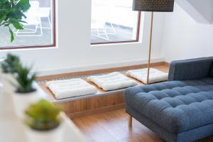 sala de estar con sofá azul y almohadas blancas en Luxury Penthouse - Augarten, en Viena