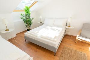 1 dormitorio con 1 cama con sábanas blancas y ventana en Luxury Penthouse - Augarten, en Viena
