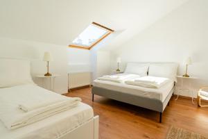 2 camas en una habitación blanca con tragaluz en Luxury Penthouse - Augarten, en Viena