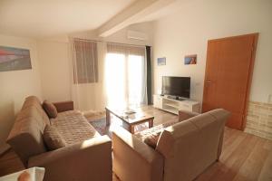 a living room with two couches and a television at Prizren Apartment's in Prizren