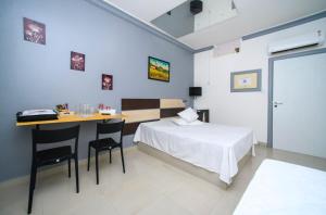 Nidore Motel في بوا فيستا: غرفة نوم بسرير وطاولة وكراسي