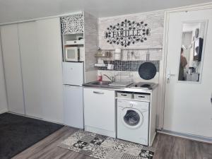 a kitchen with a washer and a washing machine at Jolie Maisonnette avec terrasse et jardin in Roissy-en-Brie