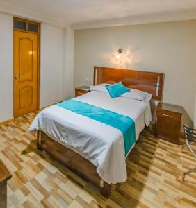 um quarto com uma cama grande e uma cabeceira em madeira em Hotel Loyalty Moquegua em Moquegua