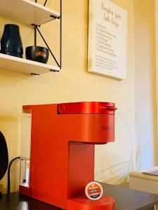 a red coffee maker sitting on top of a table at Escarpment Dwelling! in Hamilton