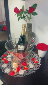 a bottle of wine in a bowl with a candle and roses at C12 Deluxe in Cap d'Agde