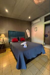 um quarto com uma cama azul e almofadas vermelhas em Hotel Brunette em Santa Ana
