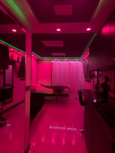 a room with pink lights and a table in it at C12 Deluxe in Cap d'Agde