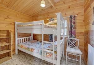 a bedroom with two bunk beds in a log cabin at West Stow Pods in Bury St Edmunds in West Stow