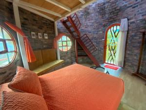 a living room with an orange couch and a brick wall at El Domo Macanal in Macanal