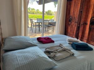 1 cama con toallas en una habitación con patio en Complexe 10 personnes piscine chauffée privée et jacuzzi, en Coudot