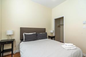 a bedroom with a bed with two night stands and two lamps at Homely Loft #5 with AC, Downtown in Halifax