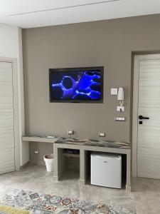 een kamer met een bureau en een tv aan de muur bij I Parienti Ra Zita in Ragusa