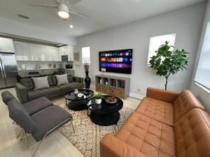 uma sala de estar com um sofá e uma televisão em Cozy 4Bed Home in Calle 8 Miami em Miami