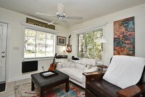 a living room with a white couch and a tv at Quaint Winter Park East End Home in Orlando