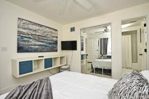 a bedroom with a bed and a tv on the wall at Quaint Winter Park East End Home in Orlando