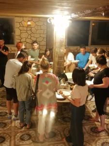 Un groupe de personnes autour d'une table avec de la nourriture dans l'établissement Dana Nabil Ecu Camp House - Main Gate Dana nature reserve, à Dana