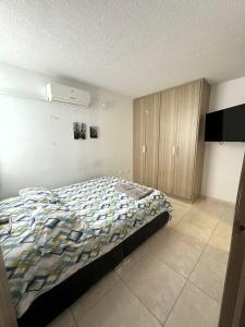 a bedroom with a bed and a tv in it at Hermoso Apartamento cerca del centro comercial jardin plaza in Cúcuta
