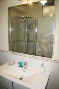 La salle de bains est pourvue d'un lavabo, d'une douche et d'un miroir. dans l'établissement One bedroom appartement at Barletta 900 m away from the beach with terrace and wifi, à Barletta