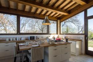 una cucina con tavolo e alcune finestre di 5 bedrooms house with private pool terrace and wifi at Ripatransone a Cossignano