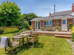 a garden with a table and chairs in front of a house at 4 bed in Bowcombe IC017 in Bowcombe