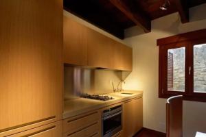 cocina con armarios de madera y horno con fogones en One bedroom property with private pool sauna and terrace at Boltana, en Boltaña