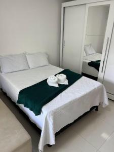 ein weißes Schlafzimmer mit 2 Handtüchern auf dem Bett in der Unterkunft Lindo apartamento 1 quarto próximo a Rua de Lazer Domingos Martins in Domingos Martins