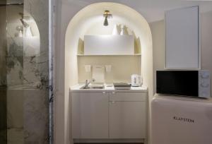 uma cozinha branca com um lavatório e um chuveiro em Il cielo in una stanza em Bérgamo