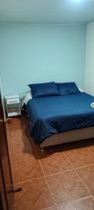a bed in a room with a blue wall at Hospedaje Room's El Dorado in Bogotá