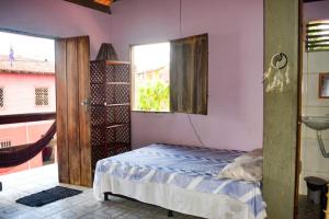 a small bedroom with a bed and a window at Studio com varanda in Itacaré