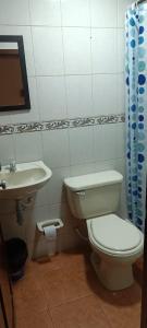 a bathroom with a toilet and a sink at Hospedaje Room's El Dorado in Bogotá