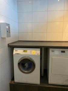 a washer and dryer under a counter in a room at Hausboot Claudia Schleswig in Schleswig